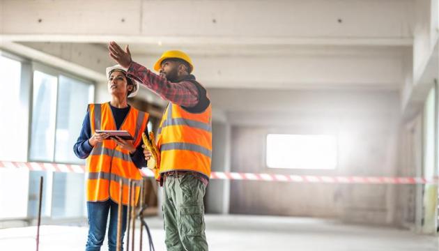 Construction worker on construction site wearing hard hat 