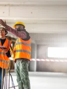 Construction worker on construction site wearing hard hat 