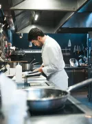 A chef cooking in the kitchen around sharp objects