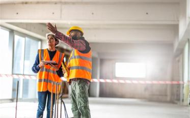 Construction worker on construction site wearing hard hat 