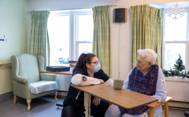 A health care worker talking to a resident in a care facility