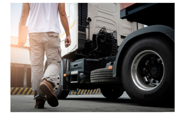 A person walking towards a parked truck.