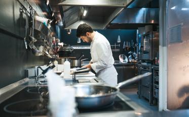 A chef cooking in the kitchen around sharp objects