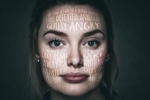 Mental-health awareness poster shows woman’s face overlaid with words expressing guilt, anger, sadness, family pressure, and emotional distress. Bold white text reads “SHARE IT. DON’T WEAR IT.