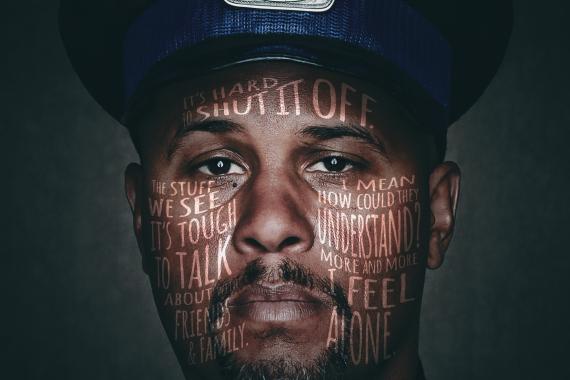 Close-up photograph of a police officer with text "Share It. Don't Wear It" in context to mental health.