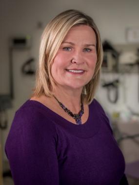Headshot of Janet Hazelton, Worker Representative, smiling in a purple outfit with a neutral background.