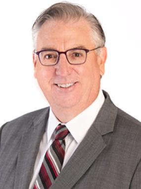 Professional headshot of Robert Patzelt, Deputy Chair, smiling in a grey suit.